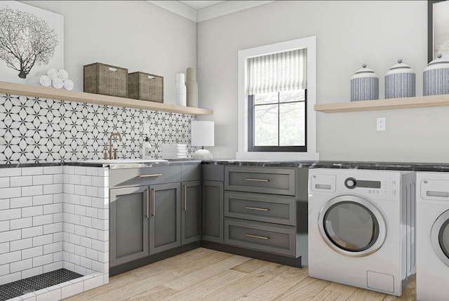 laundry area featuring cabinets, sink, light wood-type flooring, independent washer and dryer, and ornamental molding