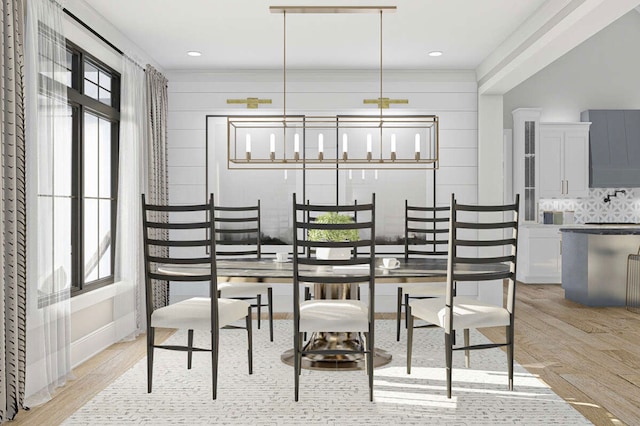 dining space with wooden walls, ornamental molding, and light wood-type flooring