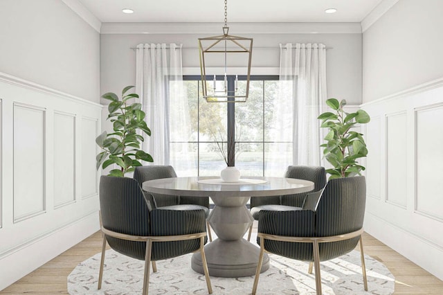 dining space featuring an inviting chandelier, ornamental molding, and light wood-type flooring