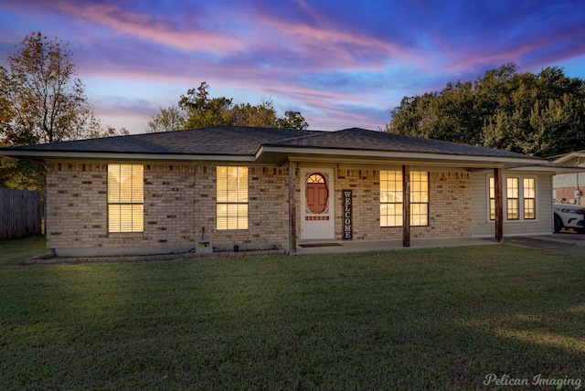 single story home with a lawn