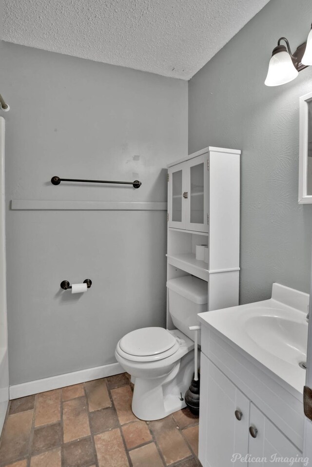 bathroom with vanity, a textured ceiling, and toilet