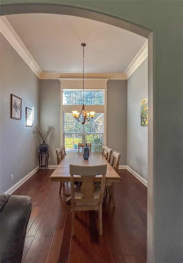 dining area with a chandelier, crown molding, and dark wood-type flooring