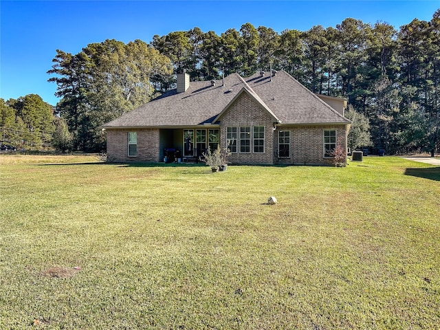 rear view of house featuring a lawn