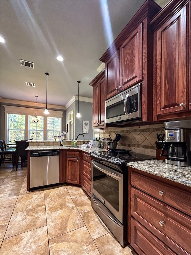 kitchen featuring light stone counters, ornamental molding, stainless steel appliances, sink, and decorative light fixtures