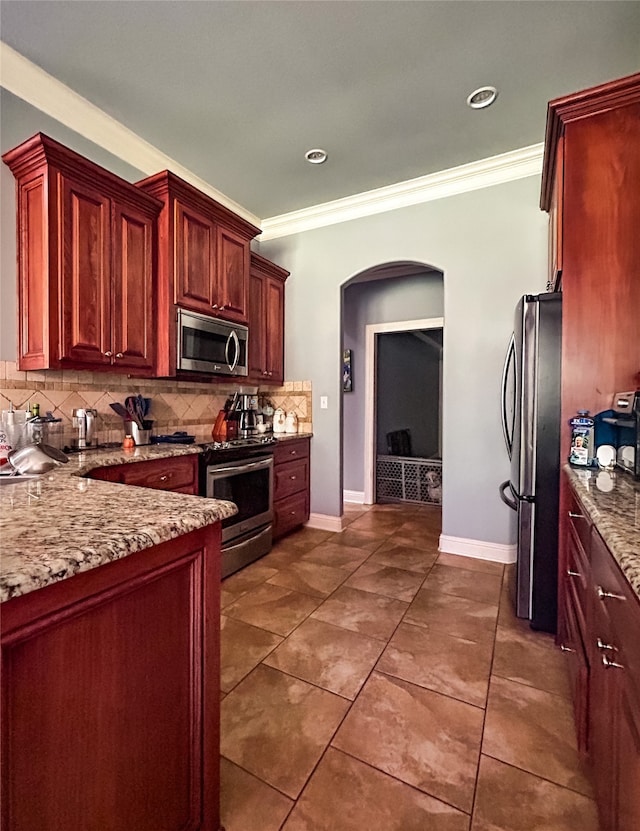 kitchen featuring appliances with stainless steel finishes, tasteful backsplash, light stone counters, and crown molding