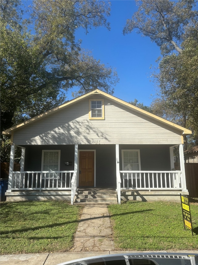 bungalow-style house featuring a porch and a front lawn