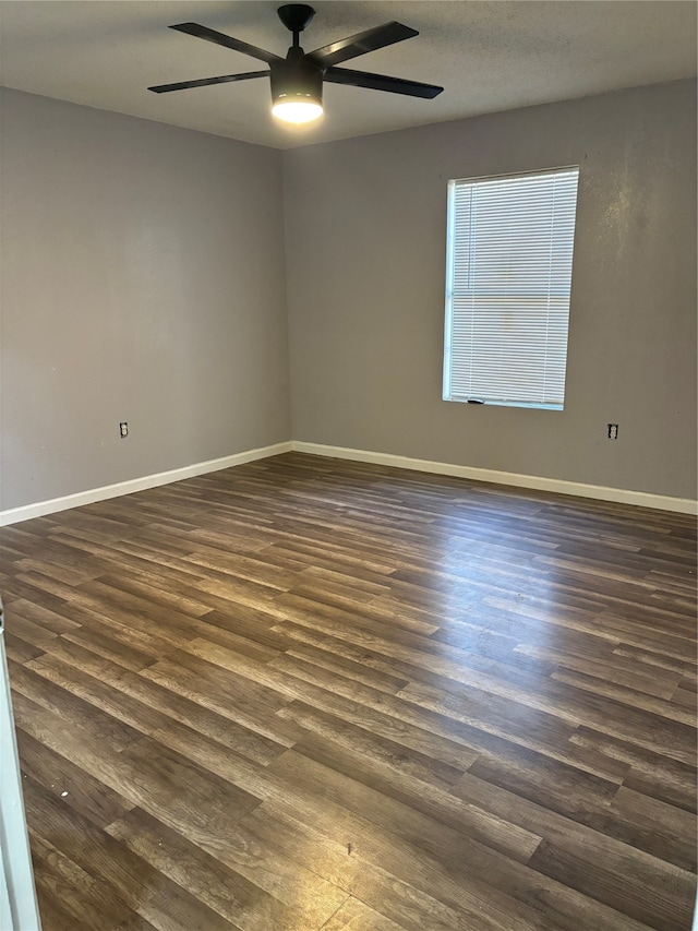 empty room featuring ceiling fan and dark wood-type flooring