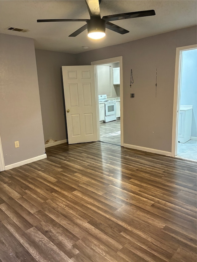 spare room with ceiling fan and dark wood-type flooring