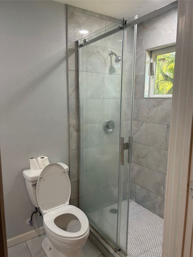 bathroom with tile patterned floors, a shower with door, and toilet