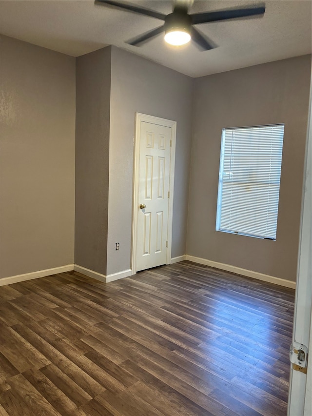 spare room featuring ceiling fan and dark wood-type flooring