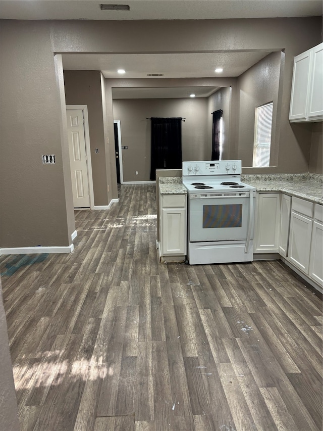 kitchen featuring electric stove, white cabinetry, dark wood-type flooring, and light stone counters