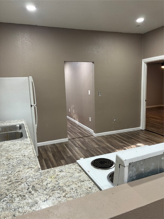 kitchen featuring sink, white appliances, and dark wood-type flooring