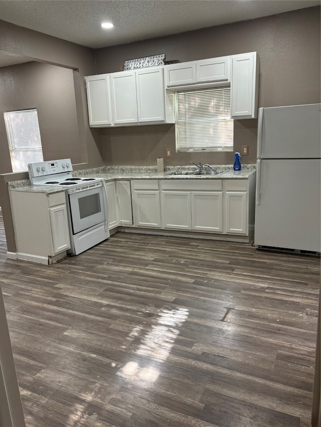 kitchen featuring white cabinetry, sink, dark wood-type flooring, and white appliances