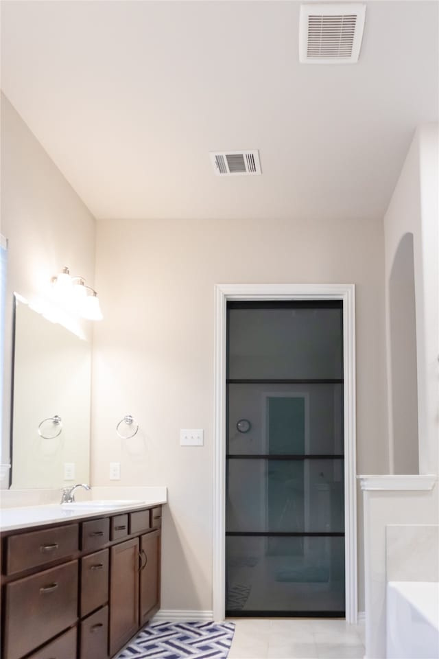 bathroom with vanity and a bath