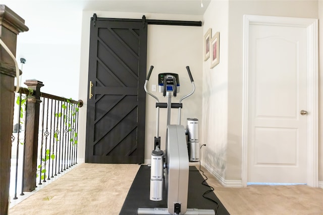 exercise room with a barn door and light colored carpet