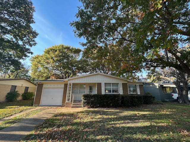 ranch-style home with a front lawn, covered porch, and a garage