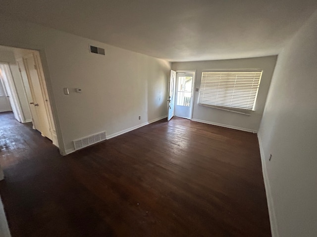 unfurnished room featuring dark wood-type flooring