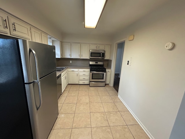 kitchen with stainless steel appliances and light tile patterned flooring