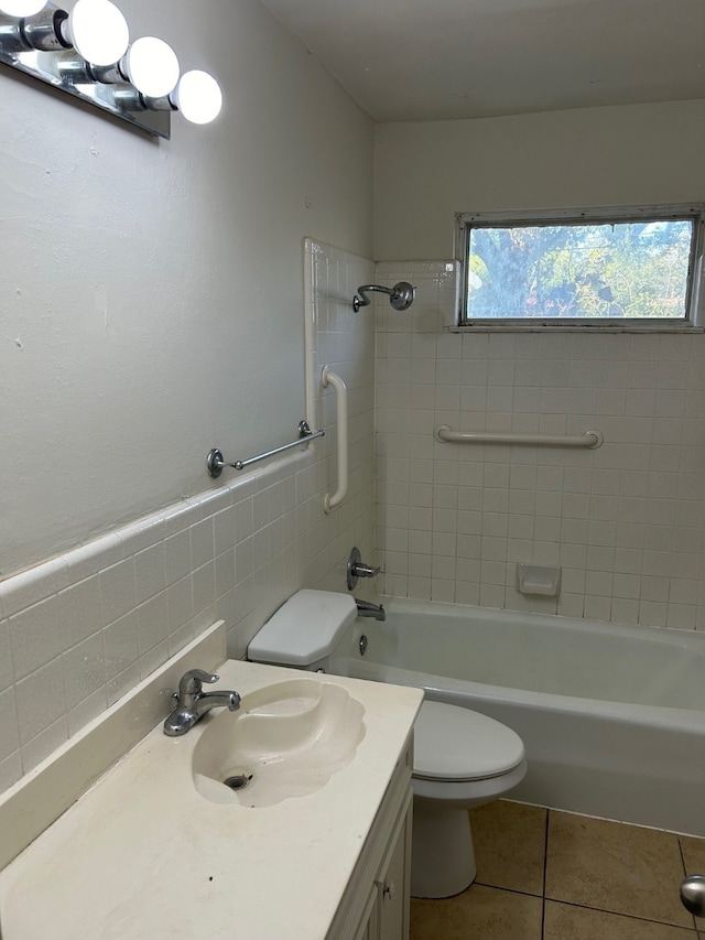 full bathroom featuring tile patterned floors, toilet, vanity, tile walls, and tiled shower / bath