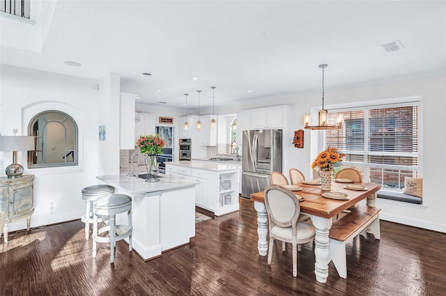 kitchen featuring kitchen peninsula, a healthy amount of sunlight, pendant lighting, and appliances with stainless steel finishes