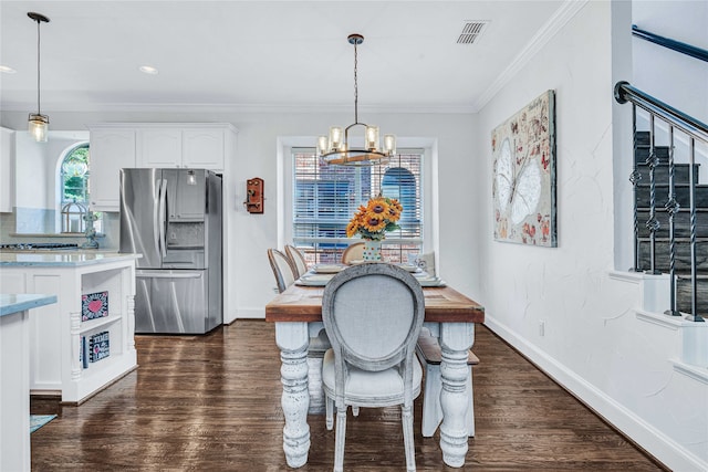 dining area with crown molding, dark wood-type flooring, and a chandelier