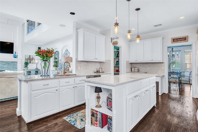 kitchen with decorative light fixtures, a kitchen island, white cabinetry, and kitchen peninsula