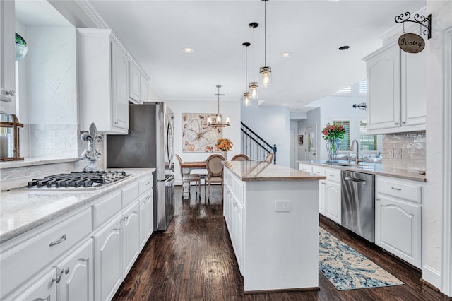 kitchen featuring white cabinetry, dark hardwood / wood-style flooring, a kitchen island, and stainless steel appliances