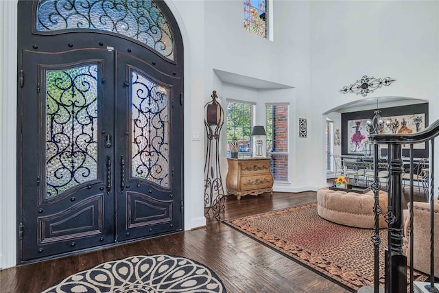 foyer with dark hardwood / wood-style flooring, a high ceiling, and french doors