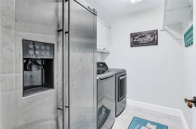 washroom with washing machine and dryer, light tile patterned floors, and cabinets