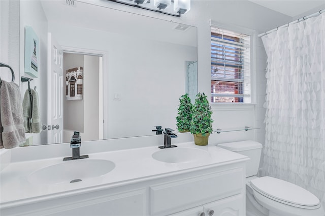 bathroom featuring vanity, toilet, and curtained shower