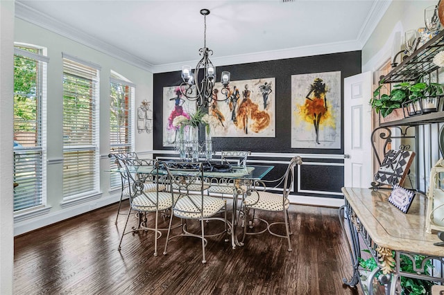 dining space with hardwood / wood-style floors, crown molding, and a chandelier