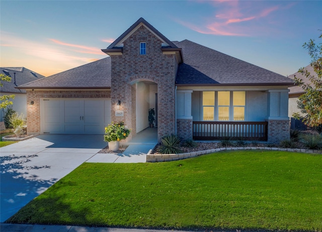 view of front of property with a garage, a porch, and a lawn