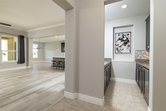 corridor with light hardwood / wood-style floors and crown molding