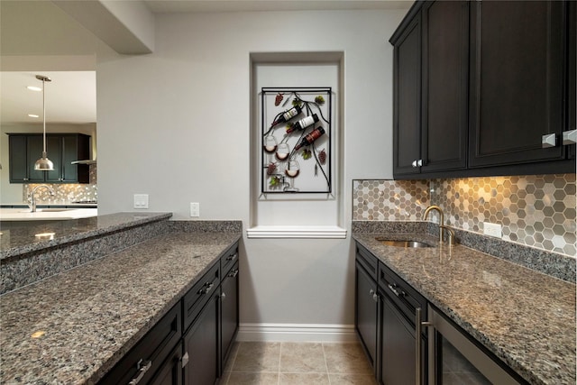 kitchen featuring sink, dark stone counters, and tasteful backsplash