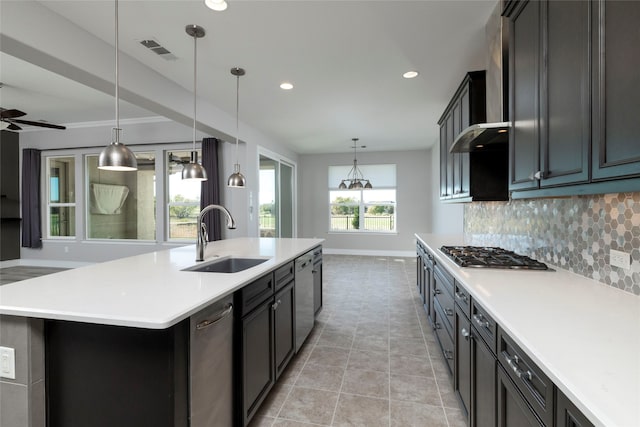 kitchen with stainless steel appliances, plenty of natural light, a kitchen island with sink, and sink