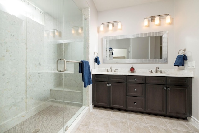 bathroom with a shower with door, vanity, and tile patterned flooring