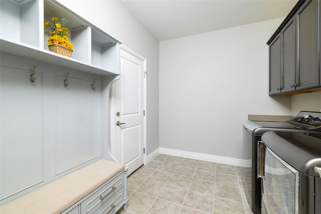 laundry room featuring cabinets, separate washer and dryer, and light tile patterned floors