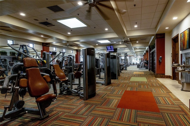 workout area featuring carpet flooring, a paneled ceiling, and ceiling fan