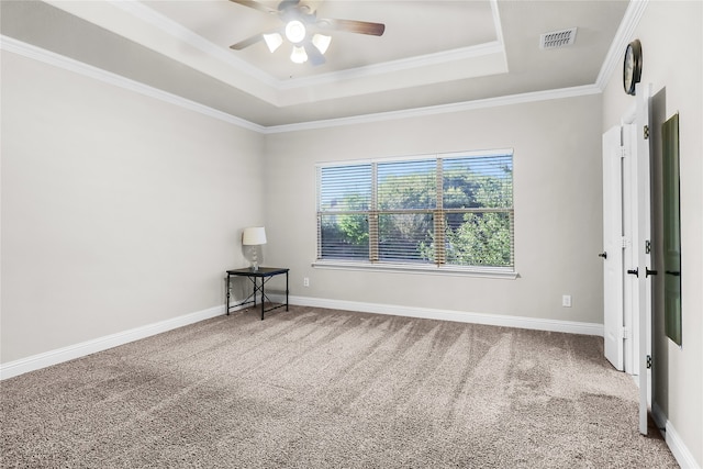 empty room featuring carpet flooring, a raised ceiling, ceiling fan, and crown molding