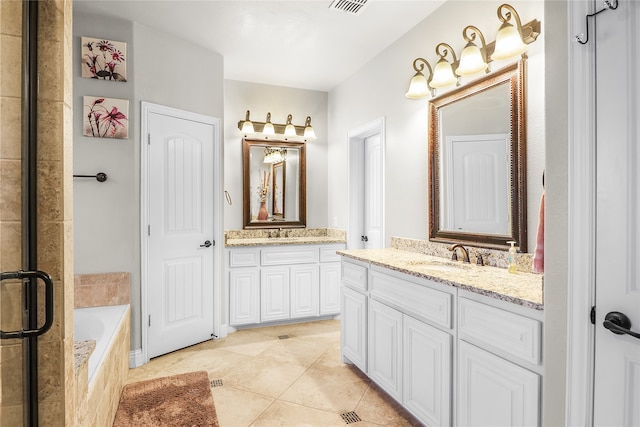 bathroom featuring vanity, tiled bath, and tile patterned floors