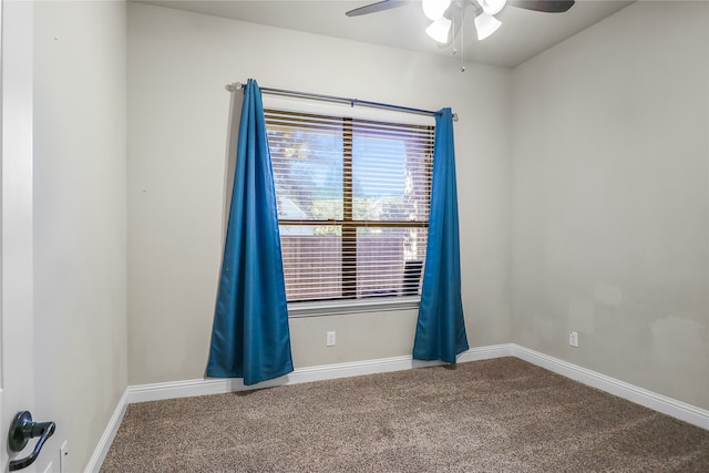 carpeted spare room featuring ceiling fan