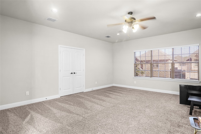 empty room with ceiling fan and carpet