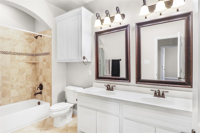 full bathroom with toilet, tile patterned flooring, vanity, and tiled shower / bath