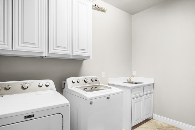 laundry area with cabinets, light tile patterned floors, separate washer and dryer, and sink