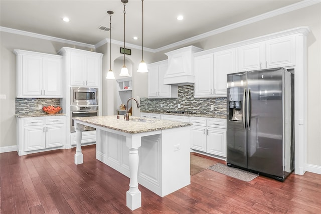 kitchen with sink, white cabinetry, stainless steel appliances, and an island with sink