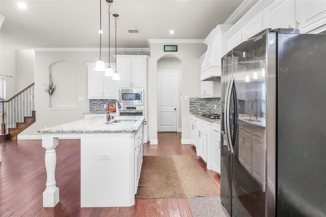 kitchen featuring a kitchen island with sink, dark hardwood / wood-style floors, appliances with stainless steel finishes, decorative light fixtures, and white cabinetry