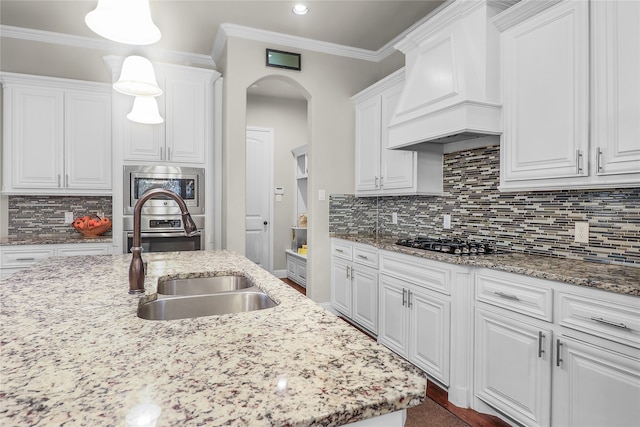 kitchen featuring pendant lighting, white cabinets, and custom range hood