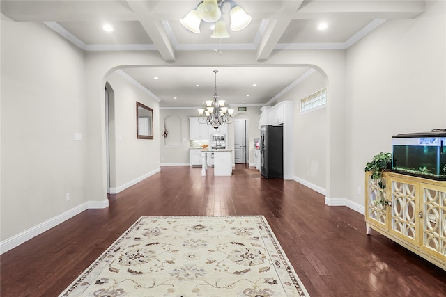 living room featuring beam ceiling, dark wood-type flooring, coffered ceiling, and an inviting chandelier