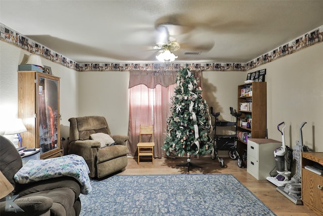 living room featuring light hardwood / wood-style flooring and ceiling fan