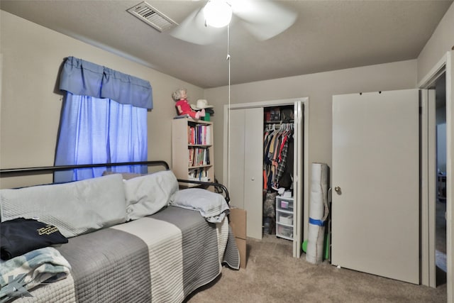 carpeted bedroom with ceiling fan and a closet